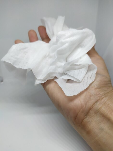 Photo close-up of hand holding white rose