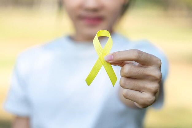 Photo close-up of hand holding yellow leaf