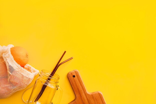 Close-up of hand holding yellow paper against orange background