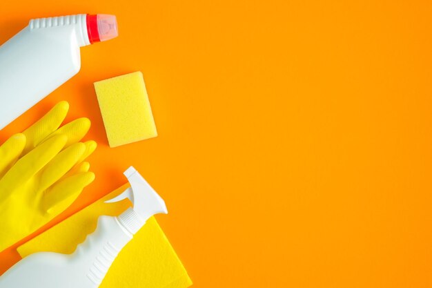 Close-up of hand holding yellow paper against orange background