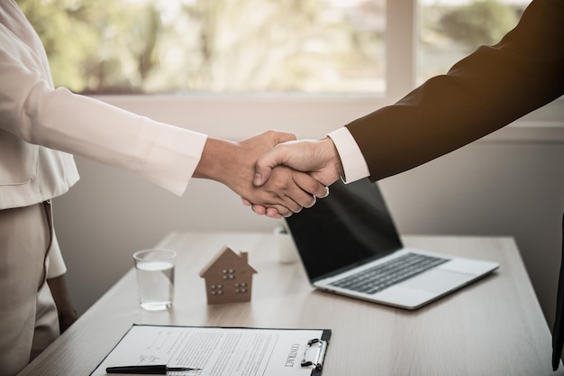 Photo close up hand of home apartment agent or realtor handshake with newlandlord tenant or rental after the banker has approved and signed the purchase contract agreement successfully property concept