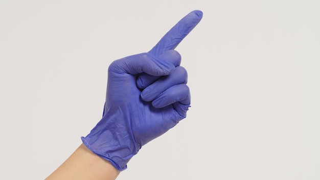 Close up of Hand is doing point finger hand sign on white background Hand wear violet or purple latex glove