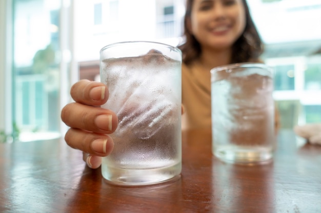 冷たい水の眼鏡を持っている手の近くに