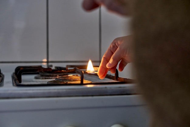 Foto close-up della mano che accende il bruciatore della stufa a gas