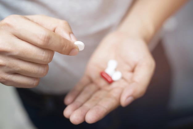 Close up hand man holding taking multiple pills. Stop drug use Taking Medication health care medical concept.