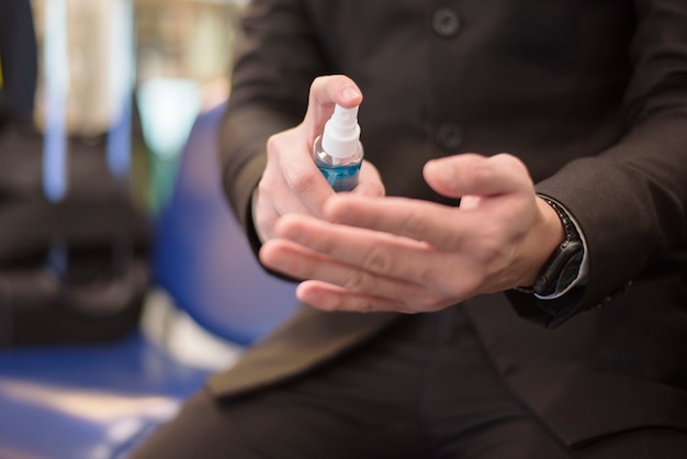 Close up hand of man  is using alcohol spray in airport