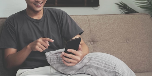 Close up hand of man using smartphone at home