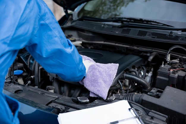 close up of hand mechanic asian man writing on a paper with wearing blue shirt professional mechanic