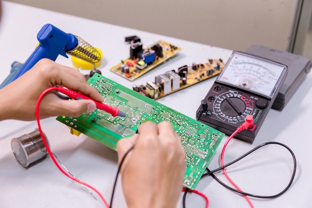 Close up of the hand men hold tool repairs electronics.