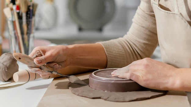 Foto close-up hand met aardewerk gereedschap