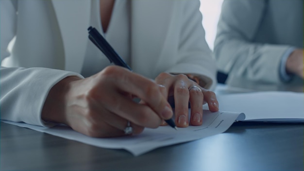 Close-up hand met pen Scheidende vrouw die documenten ondertekent in het kantoor van de advocaat