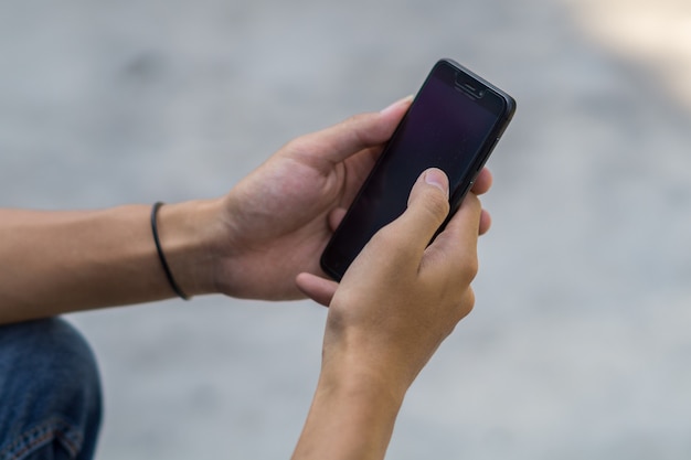 Close-up hand met zwarte telefoon