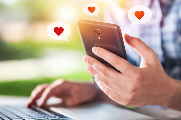 Close-up hand nemen smart phone look bericht van geliefden. Stuur een bemoedigend bericht.