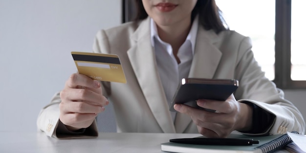 Фото Крупным планом рука деловой женщины с помощью кредитной карты и мобильного смартфона для платежей и покупок в интернете интернет-магазины цифровой банкинг концепция электронной коммерции