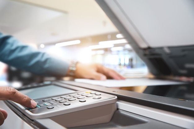 Close up hand office man press copy button on panel to using the photocopier