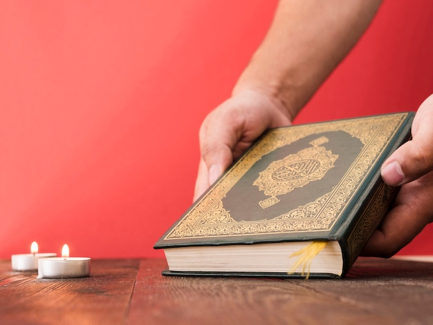 Photo close up hand picking up quran