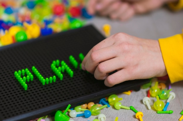 Photo close-up of hand playing game with text on table