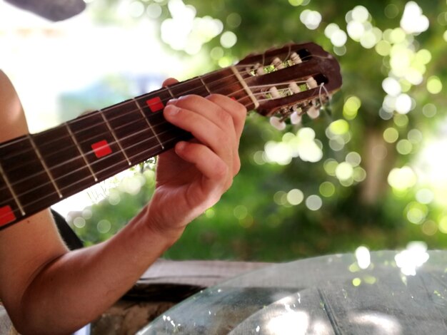 Foto close-up di una mano che suona la chitarra