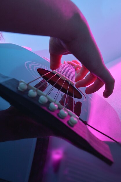 Foto close-up di una mano che suona la chitarra