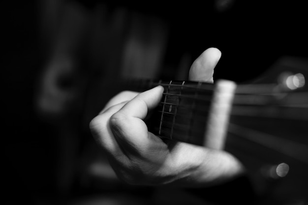 Photo close-up of hand playing guitar