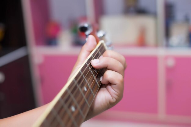 Foto close-up di una mano che suona la chitarra