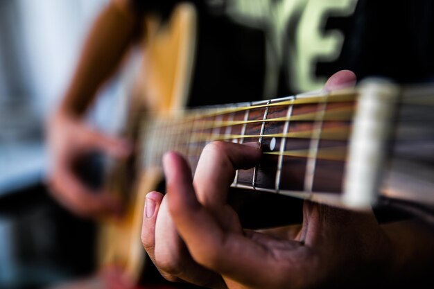 Foto close-up di una mano che suona la chitarra