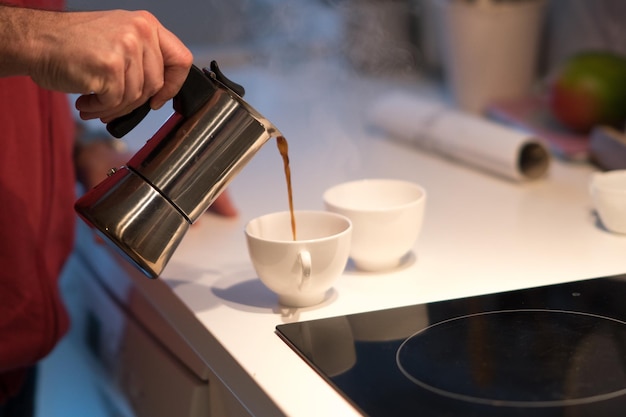 Photo close-up of hand pouring coffee in cup