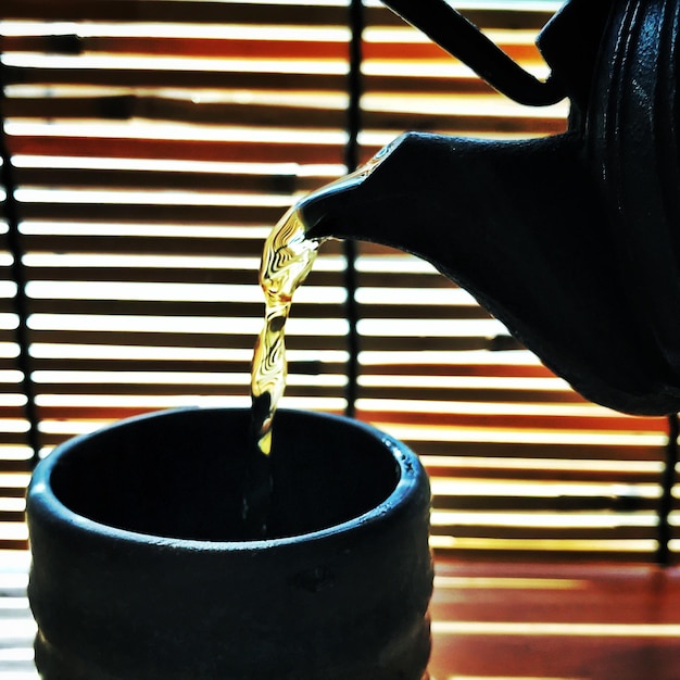 Foto close-up di una tazza di tè versata a mano