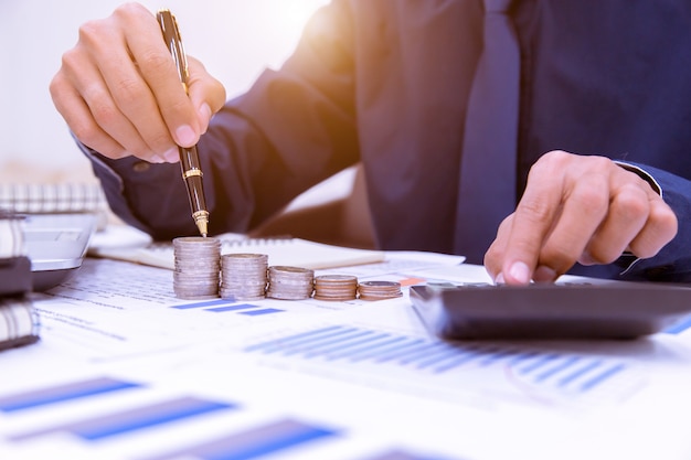 Photo close up,hand putting money coins stack in saving money and growing business concept.