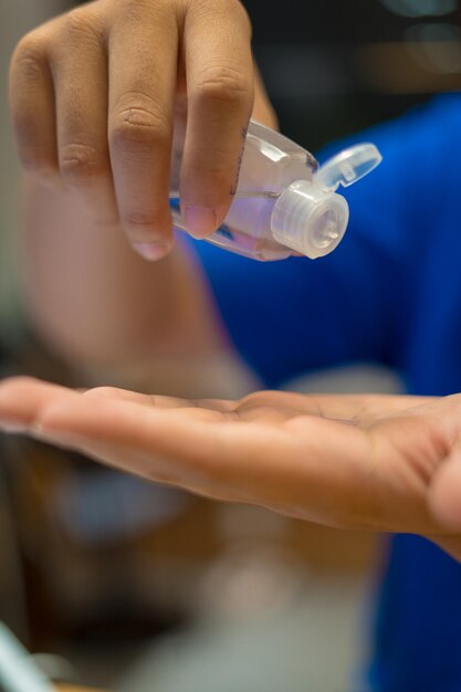 Close up hand sanitizer man applying sanitizing gel liquid rubbing hands clean personal hygiene