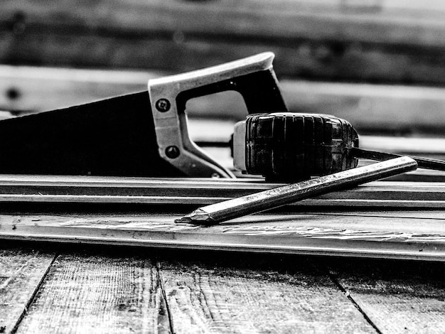 Photo close-up of hand saw on wooden table