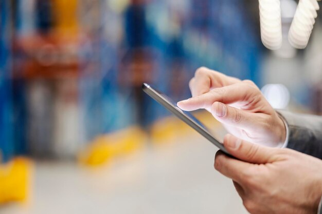 Close up of a hand scrolling on tablet in warehouse