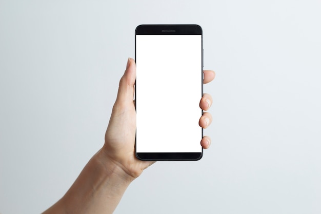 Close-up in the hand of a smartphone with a white screen on a white background. 