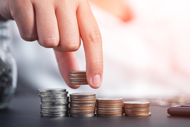 Close-up of hand stacking coins