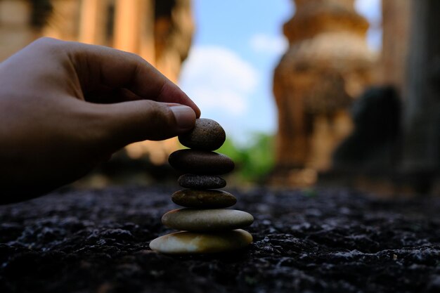 Close-up of hand stacking pebbles