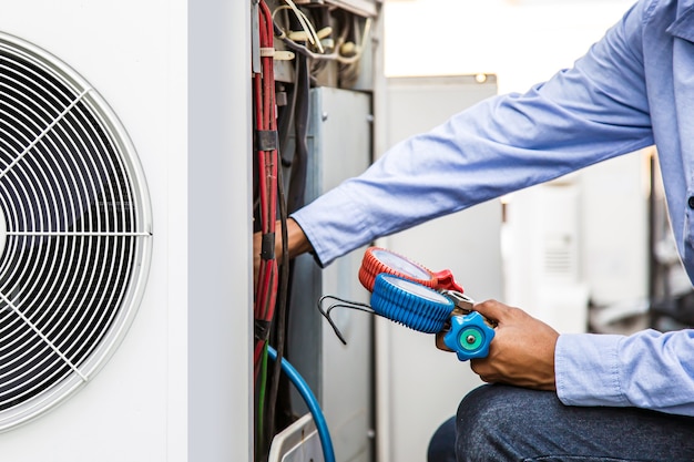 Close up hand of technician using manifold gauge to filling air conditioners.