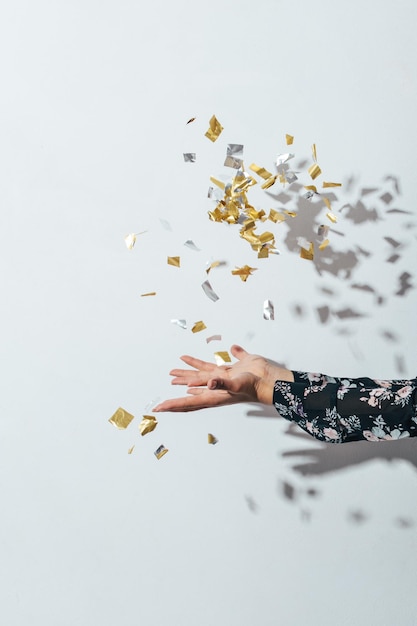 Photo close-up of hand throwing confetti