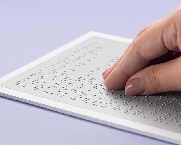 Photo close-up hand touching braille alphabet