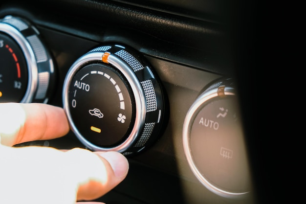 車のダッシュボードに触れる手のクローズアップ
