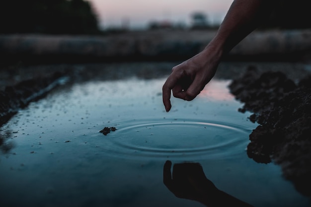 Photo close-up of hand touching water