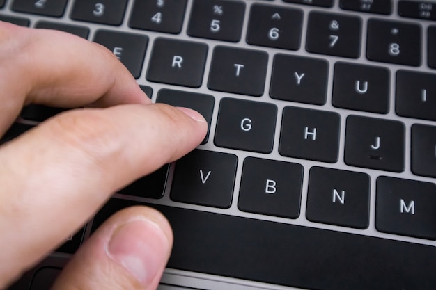 Close up of hand type on laptop keyboard