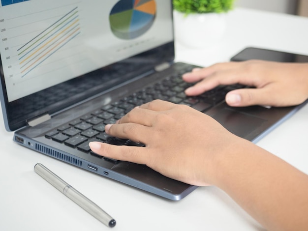 Close up hand using laptop charts graphs business at screen on the table