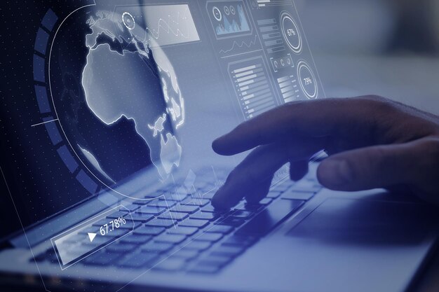 Close up of hand using laptop computer with creative glowing digital business screen interface globe and charts on blurry background Spy hud and world concept Double exposure