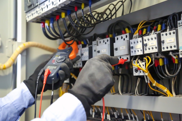 Close-up hand using measuring tool to checking electricity at circuit breaker.