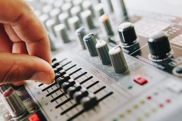 Photo close-up of hand using sound mixer