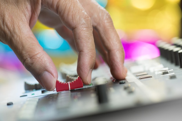 Photo close-up of hand using sound mixer