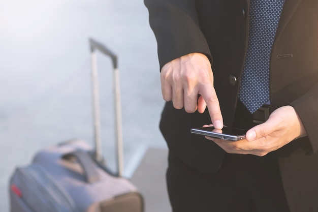 Close-up hand van zakenman met behulp van tekst mobiele smartphone houden apparaat en scherm aan te raken. of Neem contact op met de klant.