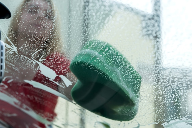 Close up of hand washing car with sponge and soap foam