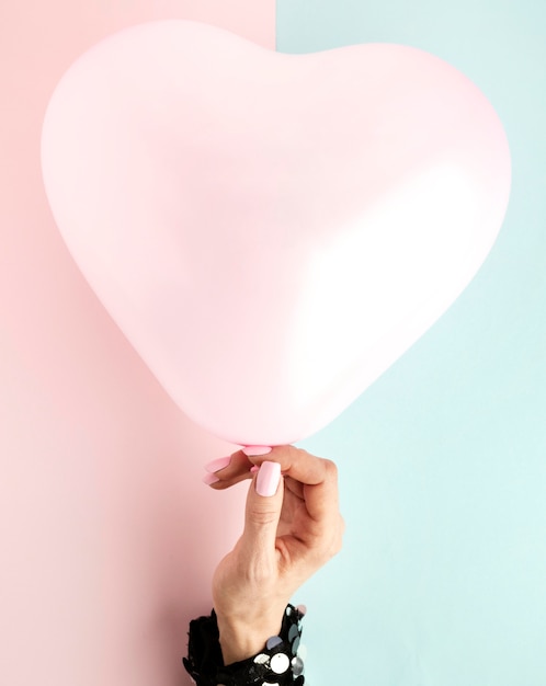 Photo close up hand with heart shaped balloon