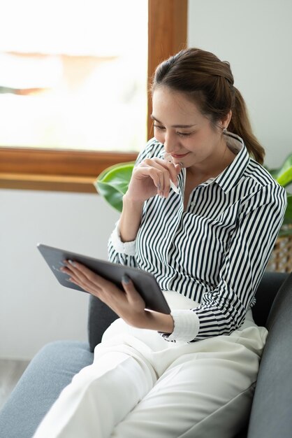 現代のオフィスでタブレットとペンのスタイラスを保持している女性マネージャーの手をクローズアップ